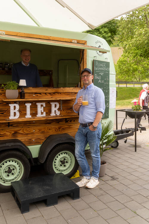 Die Chefs der Pleiner Biermanufaktur stehen an ihrem Anhänger und lächeln in die Kamera.