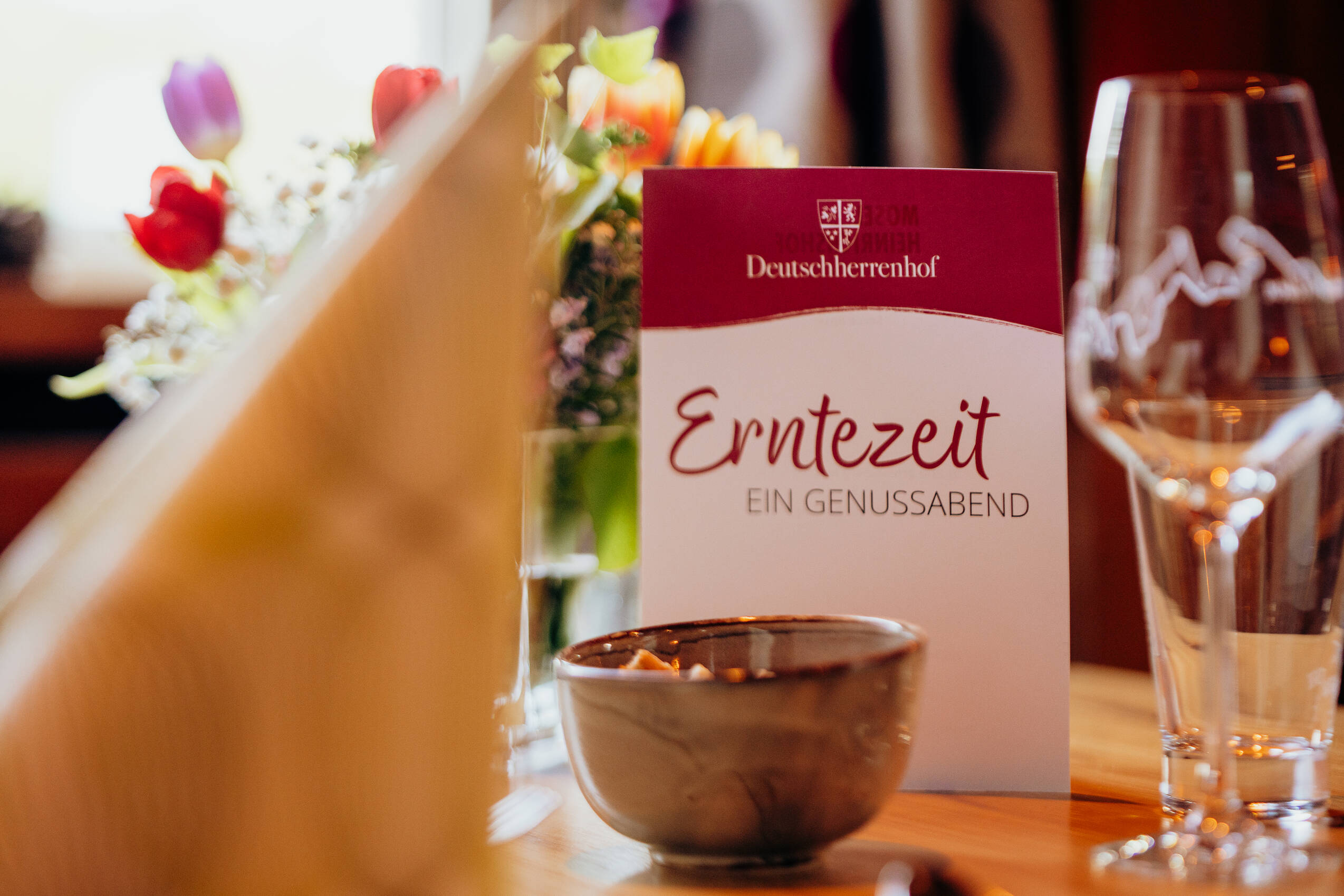 Auf dem gedeckten Tisch steht die Menükarte für das Erntezeitmenü.
