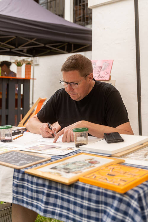 Künstler Laurent Bessot zeichnet an seinem Stand.